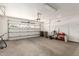 Spacious two-car garage featuring a roll-up door and ample storage space for vehicles and equipment at 15674 W Mackenzie Dr, Goodyear, AZ 85395
