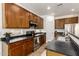 Kitchen boasts stainless steel appliances, dark countertops and cabinetry with tile flooring at 15674 W Mackenzie Dr, Goodyear, AZ 85395