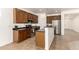 Kitchen with stainless steel appliances, dark cabinets, and a breakfast bar open to the living area at 15674 W Mackenzie Dr, Goodyear, AZ 85395