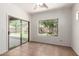 Living room featuring tile flooring, a sliding glass door to the backyard, and a large window overlooking the yard at 15674 W Mackenzie Dr, Goodyear, AZ 85395