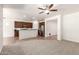 Open concept living room and kitchen with stainless steel appliances, ceiling fan, and lots of natural light at 15674 W Mackenzie Dr, Goodyear, AZ 85395
