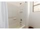 Tiled shower and bathtub combination with a window at 15674 W Mackenzie Dr, Goodyear, AZ 85395
