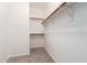 Bright, empty walk-in closet with neutral carpet and painted white and multiple hanging rods for optimal storage at 15674 W Mackenzie Dr, Goodyear, AZ 85395