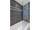 Bathroom with a bathtub-shower featuring a glass partition and contemporary gray and blue tile work at 1617 W Lamar Rd, Phoenix, AZ 85015