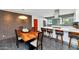 Dining room with a wooden table set for four, brick wall, and kitchen in background at 1617 W Lamar Rd, Phoenix, AZ 85015