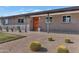 Inviting exterior featuring desert landscaping, brickwork, and a brightly painted orange entry door at 1617 W Lamar Rd, Phoenix, AZ 85015