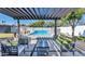 Inviting outdoor living space featuring a sparkling pool with a pergola-covered patio and comfortable seating at 1617 W Lamar Rd, Phoenix, AZ 85015