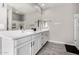 Bright bathroom featuring double sinks, a large mirror, and white cabinets at 17171 W Tonto St, Goodyear, AZ 85338