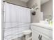 This bathroom features a shower with a black and white curtain, a white vanity, and modern fixtures at 17171 W Tonto St, Goodyear, AZ 85338