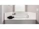 White soaking tub with modern fixtures and black towels at 17171 W Tonto St, Goodyear, AZ 85338