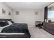 Simple bedroom with black upholstered bed, carpeted floor, and neutral walls at 17171 W Tonto St, Goodyear, AZ 85338