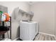This laundry room features wood-look floors, a front load washer, and a dryer with extra storage at 17171 W Tonto St, Goodyear, AZ 85338
