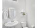 Half bathroom with pedestal sink, round mirror, floating shelves, and toilet at 1727 E Chelsea Ln, Gilbert, AZ 85295