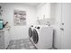 Well-organized laundry room with modern washer and dryer, stylish tiled floors, and ample storage at 1831 E Cornell Dr, Tempe, AZ 85283