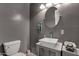 Stylish powder room featuring modern vessel sink, oval mirror, and textured gray walls at 18501 E Pine Valley Dr, Queen Creek, AZ 85142