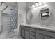 Well-lit bathroom featuring dual sinks, large mirrors, glass block shower, and stylish gray cabinetry at 18501 E Pine Valley Dr, Queen Creek, AZ 85142