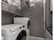 Functional laundry room with stackable washer/dryer, overhead shelving, and ample storage cabinets at 18501 E Pine Valley Dr, Queen Creek, AZ 85142