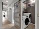 Convenient laundry area with sliding barn door, stackable washer/dryer, and built-in shelving at 18501 E Pine Valley Dr, Queen Creek, AZ 85142