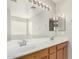 Primary bathroom featuring double sinks, oak cabinets and large mirror at 2191 W Goldmine Mountain Dr, Queen Creek, AZ 85144
