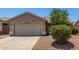 Front view of charming home showcasing low maintenance landscaping, stucco exterior and two car garage at 2191 W Goldmine Mountain Dr, Queen Creek, AZ 85144