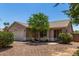 Single level home with desert landscaping including mature trees and bushes and a two car garage at 2191 W Goldmine Mountain Dr, Queen Creek, AZ 85144