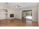 Spacious living room featuring laminate floors, modern ceiling fan, fireplace, and sliding glass doors at 2191 W Goldmine Mountain Dr, Queen Creek, AZ 85144