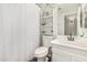 Bathroom features white vanity, sink, toilet, decorative wall accents, and shower with curtain at 22056 N 32Nd Ave, Phoenix, AZ 85027