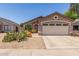 Front view of a single-story house with a two-car garage and desert landscaping at 22056 N 32Nd Ave, Phoenix, AZ 85027