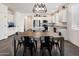 Dining area adjacent to a kitchen features a wooden table set with black metal chairs and tile flooring at 25119 N 134Th Dr, Peoria, AZ 85383