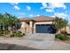 Lovely single-story home boasts a neutral color palette, stone accents, and a two-car gray garage door at 25119 N 134Th Dr, Peoria, AZ 85383