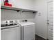 Laundry room featuring modern washer and dryer units, and overhead shelving at 25119 N 134Th Dr, Peoria, AZ 85383