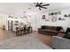 Open concept living area adjacent to the kitchen has carpeting, ceiling fan, and dark-colored sectional sofas at 25119 N 134Th Dr, Peoria, AZ 85383