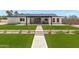 Manicured backyard with artificial turf, desert landscaping, and a stone paver walkway at 26626 N 70Th Pl, Scottsdale, AZ 85266