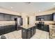 Well-lit kitchen featuring dark cabinets, stainless steel appliances, and a granite-topped island at 2853 E Cathy Dr, Gilbert, AZ 85296