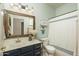 Bright bathroom with blue vanity, white countertop, large mirror, and shower with striped curtains at 3098 E Stottler Dr, Gilbert, AZ 85296
