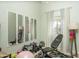 Bedroom with weights, workout bench, wall-mounted mirrors, and curtained window at 3098 E Stottler Dr, Gilbert, AZ 85296