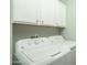 Laundry room with front-loading washer and dryer, and white storage cabinets overhead at 3098 E Stottler Dr, Gilbert, AZ 85296