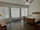 Bright bedroom featuring a large window with seating, ceiling fan, and wood-look flooring at 3139 E Runaway Bay Pl, Chandler, AZ 85249