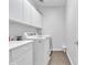 Bright laundry room with white cabinets above machines, counter space, and modern appliances on wood-look flooring at 3139 E Runaway Bay Pl, Chandler, AZ 85249