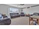Spacious living room featuring leather couches, carpeted floors, and a ceiling fan at 3139 E Runaway Bay Pl, Chandler, AZ 85249