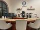 Coffee bar featuring a stainless steel refrigerator, countertop, and several coffee making appliances at 3301 S Goldfield Rd # 6050, Apache Junction, AZ 85119