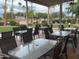 Community poolside patio with tables and chairs, perfect for relaxing and socializing by the pool at 3301 S Goldfield Rd # 6050, Apache Junction, AZ 85119