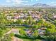 Aerial view highlighting community amenities, including a playground, splash pad, and basketball court, all within lush landscapes at 3574 E Latham Way, Gilbert, AZ 85297