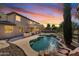 Beautiful backyard features a custom pool, outdoor kitchen, and manicured landscaping, creating a private oasis at sunset at 3574 E Latham Way, Gilbert, AZ 85297