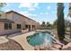 Stunning backyard with a custom pool, lush landscaping, and an outdoor kitchen, perfect for entertaining and relaxing at 3574 E Latham Way, Gilbert, AZ 85297