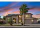 Stunning two-story home featuring a spacious three-car garage, lush landscaping, and a welcoming front entrance at sunset at 3574 E Latham Way, Gilbert, AZ 85297