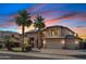Beautiful two-story home featuring a spacious three-car garage and lush landscaping at twilight at 3574 E Latham Way, Gilbert, AZ 85297