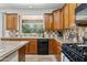 Kitchen with wooden cabinets, tile countertops, and black appliances, great view to outside at 3574 E Latham Way, Gilbert, AZ 85297