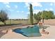 Inviting pool area with rock waterfall features, surrounded by lush landscaping and a secure wrought iron fence at 3574 E Latham Way, Gilbert, AZ 85297