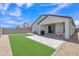 Landscaped backyard with artificial turf, a paver patio, and a covered patio, ideal for entertaining at 38150 W San Sisto Ave, Maricopa, AZ 85138